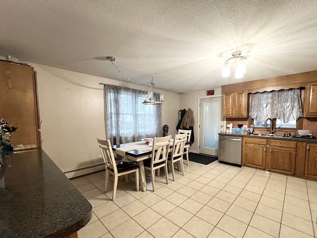 107 Enfield Street Springfield, MA 01151 - Photo 4 of 20 a kitchen with a dining table chairs and white appliances