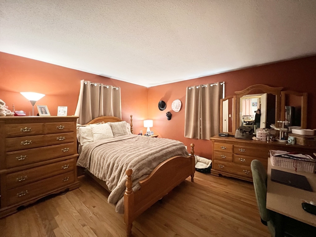 107 Enfield Street Springfield, MA 01151 - Photo 9 of 20 a bedroom with a bed and wooden floor