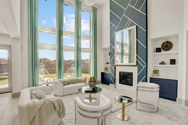 a living room with furniture a fireplace and a floor to ceiling window