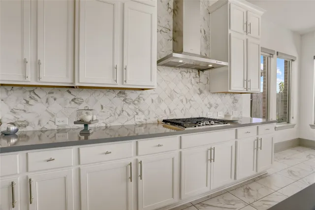 a kitchen with granite countertop white cabinets stainless steel appliances and a counter space