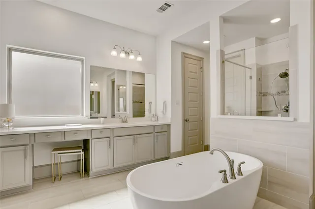 a spacious bathroom with a double vanity sink a mirror and a bathtub
