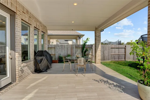 a view of a patio with table and chairs and potted plants