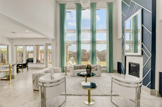 a living room with furniture fireplace and floor to ceiling windows