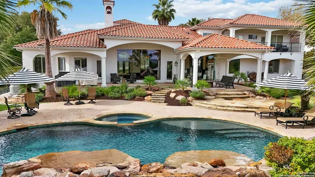 a front view of a house with swimming pool patio and swimming pool