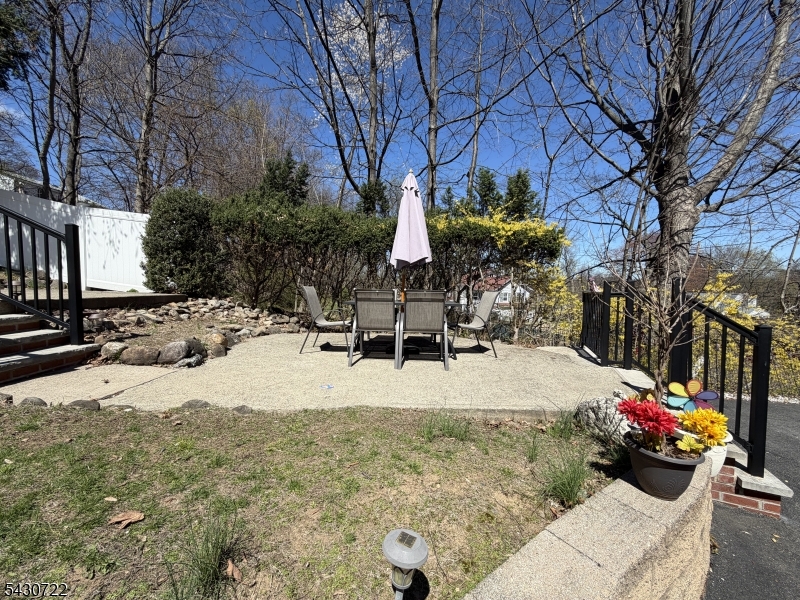 544 Goffle Hill Road Hawthorne, NJ 07506 - Photo 23 of 26 a view of a backyard with a table and chairs and a barbeque