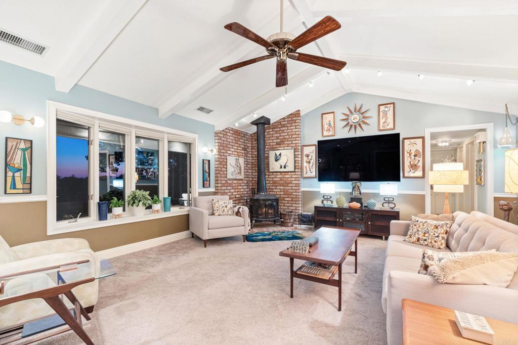 29460 Twain Valley Center, CA 92082 - Photo 32 of 75 a living room with furniture floor to ceiling window hardwood floor and a flat screen tv