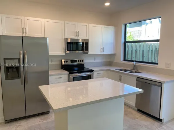 a kitchen with stainless steel appliances a microwave sink and refrigerator