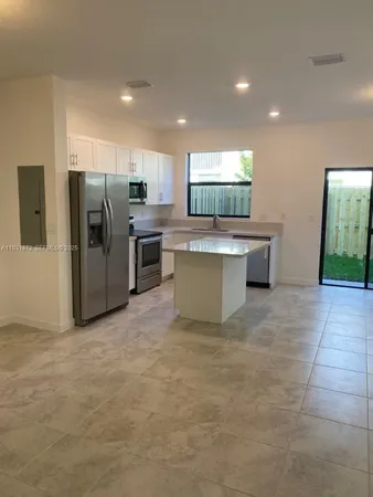 a view of kitchen with stainless steel appliances granite countertop refrigerator sink and stove