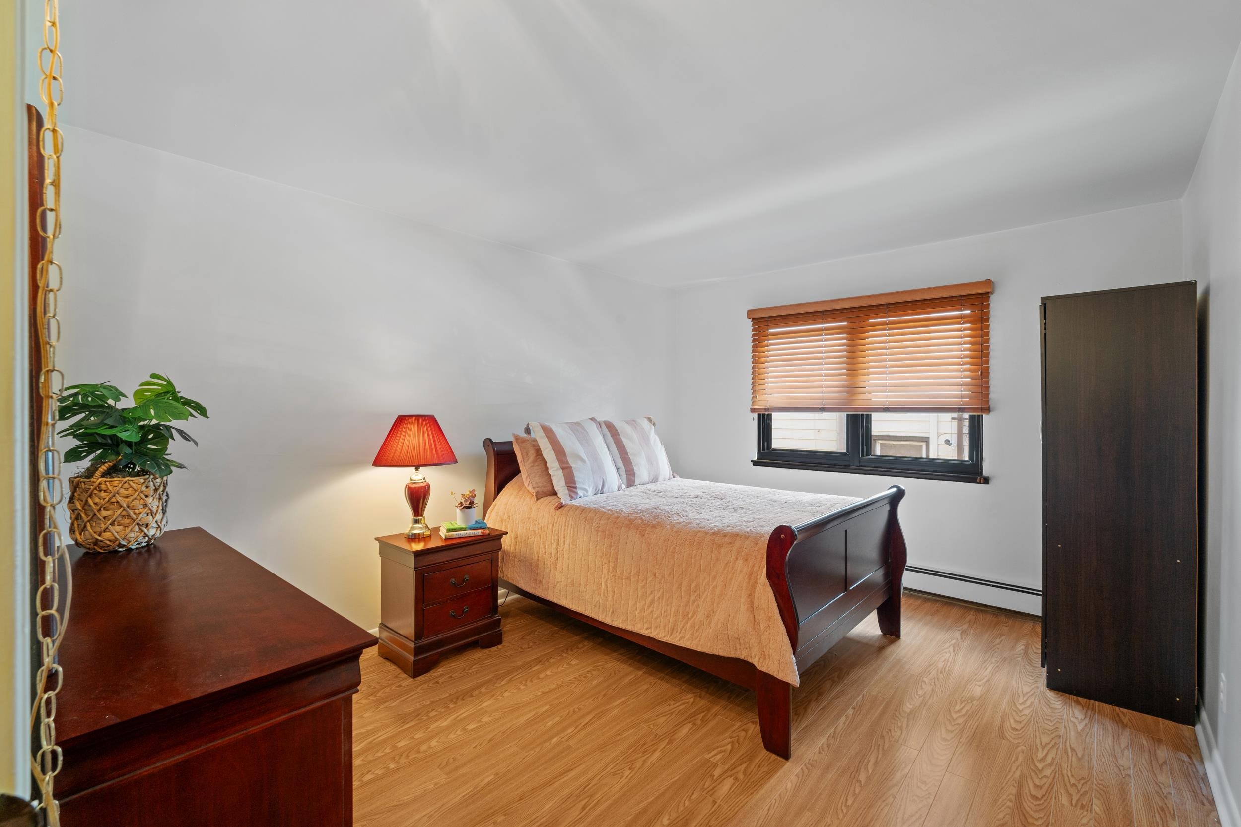 56 68th Street, Unit 8 Guttenberg, NJ 07093 - Photo 14 of 27 a living room with a bed furniture and a potted plant
