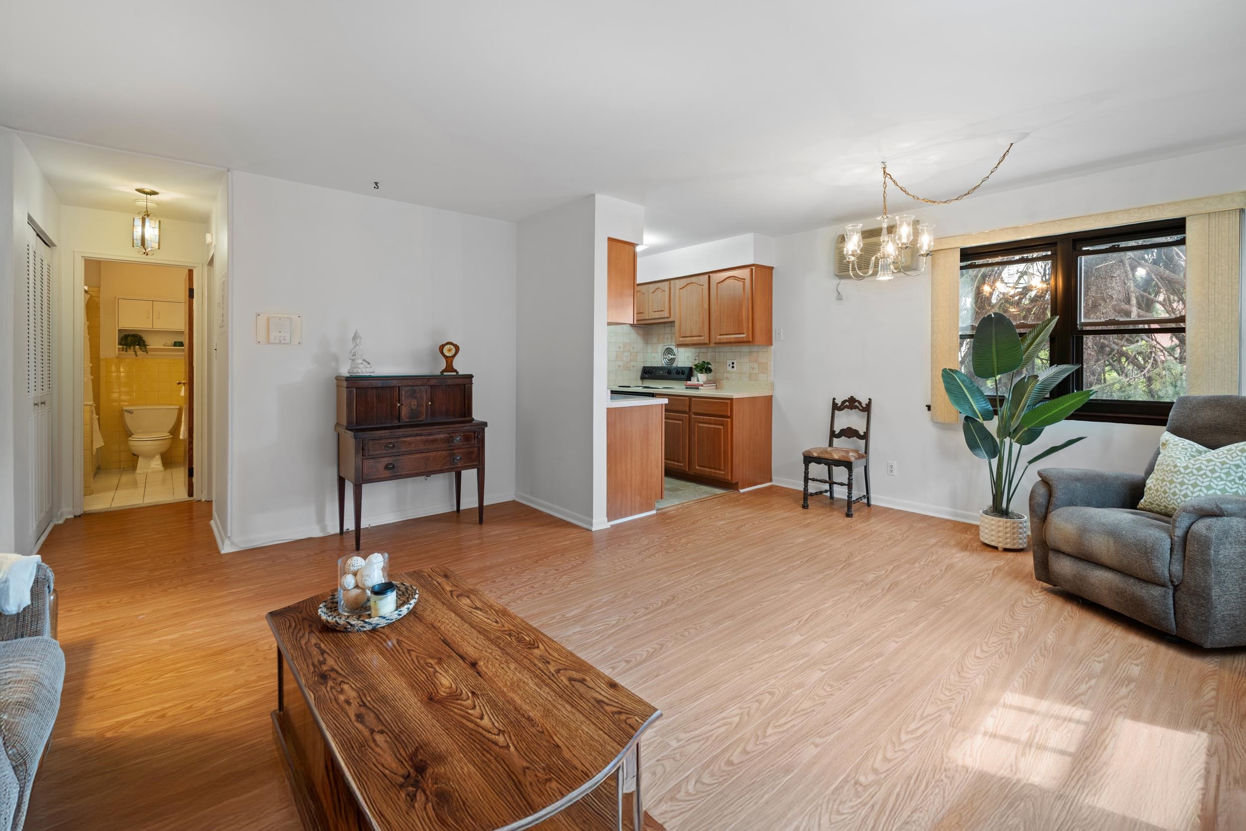 56 68th Street, Unit 8 Guttenberg, NJ 07093 - Photo 6 of 27 a living room with furniture a window and a flat screen tv