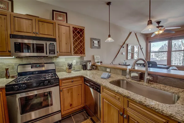 a kitchen with stainless steel appliances granite countertop a sink a stove and cabinets