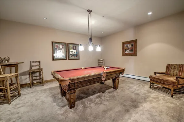 a room with pool table and windows