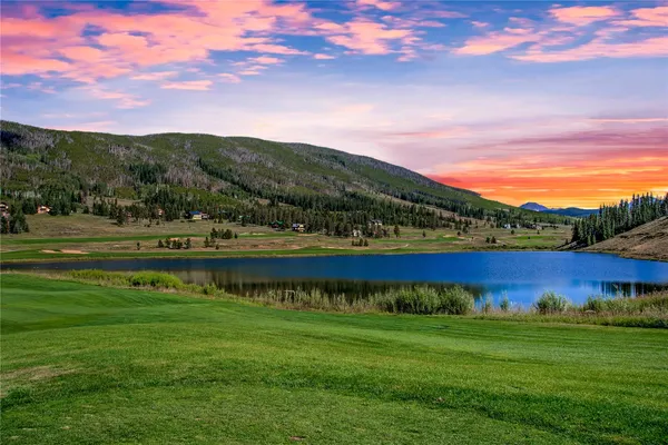a view of a swimming pool with an outdoor seating a yard and mountain view in back