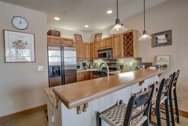 a kitchen with stainless steel appliances granite countertop a sink a stove and a refrigerator