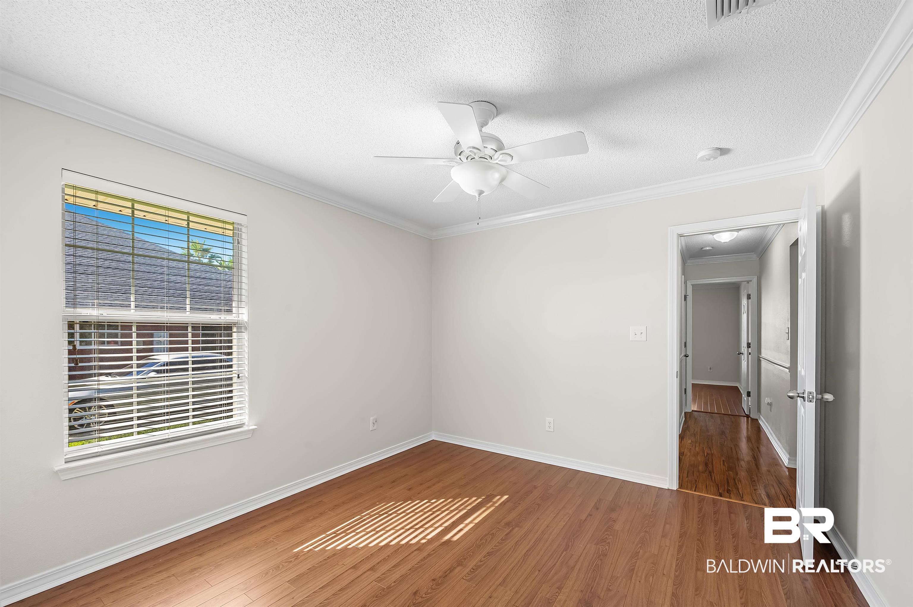421 Collinwood Loop Foley, AL 36535 - Photo 48 of 62 Empty room with ornamental molding, dark hardwood / wood-style floors, a textured ceiling, and ceiling fan