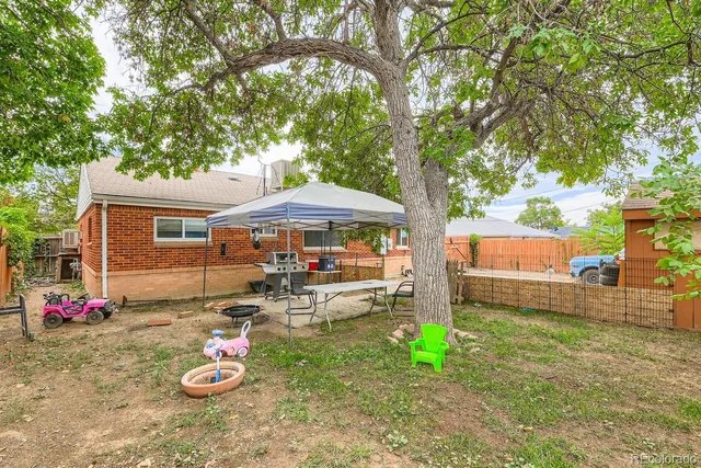 a view of backyard with table and chairs under an umbrella