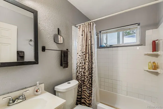 a bathroom with a toilet a sink and shower