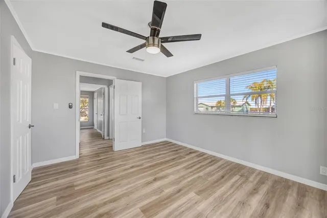 a view of an empty room with window and wooden floor