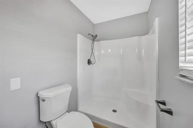 a view of an empty room with a fireplace and a window