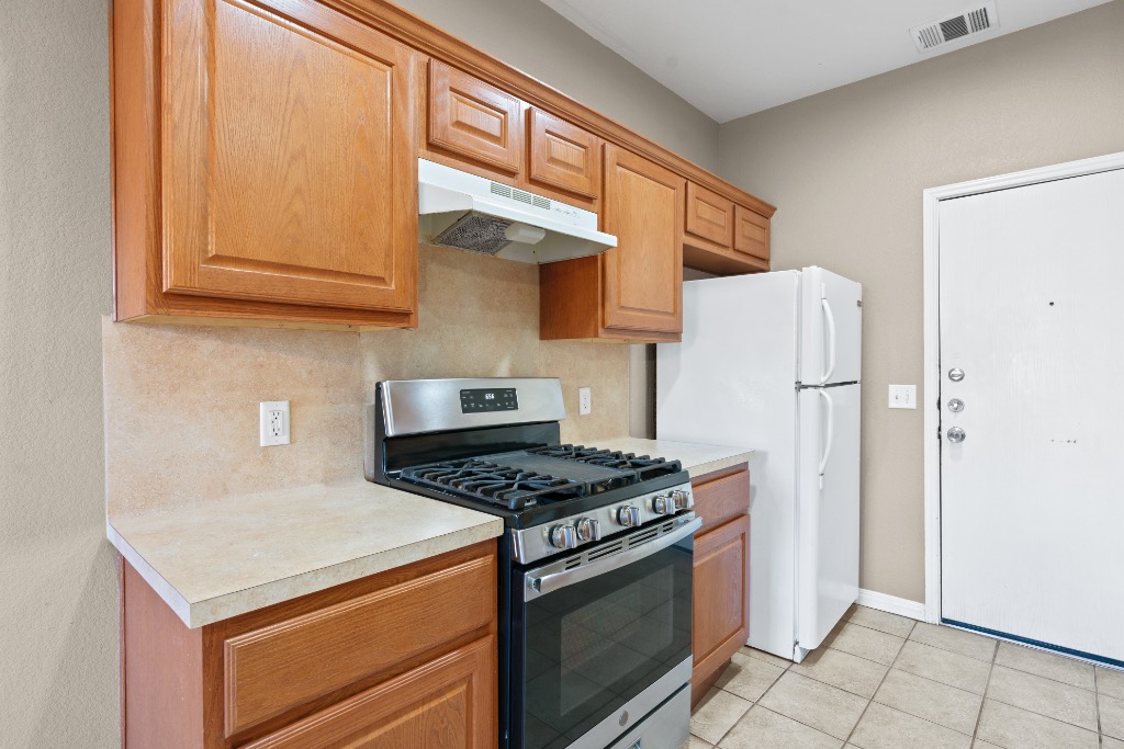 7502 Lazy Creek Drive, Unit B Austin, TX 78724 - Photo 4 of 24 a kitchen with stainless steel appliances granite countertop a stove a refrigerator and a refrigerator