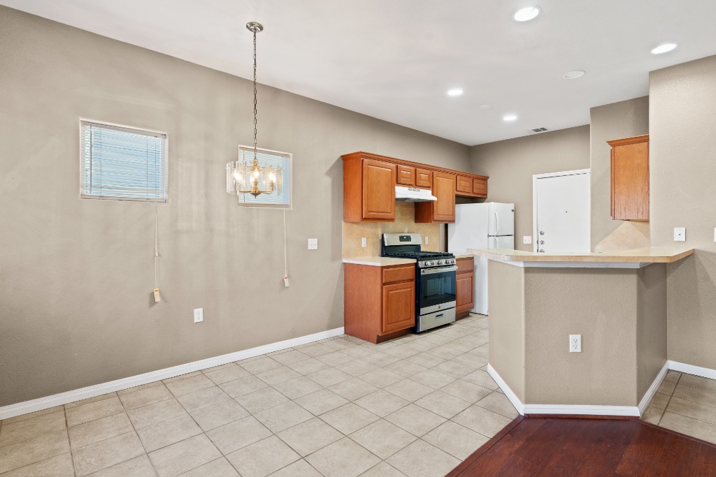 7502 Lazy Creek Drive, Unit B Austin, TX 78724 - Photo 6 of 24 a kitchen with stainless steel appliances kitchen island granite countertop a refrigerator and a stove top oven
