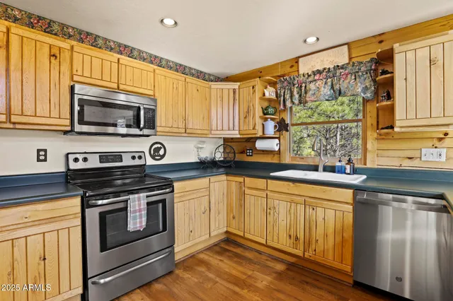 a kitchen with stainless steel appliances granite countertop a stove a sink and a microwave