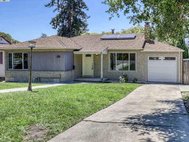a front view of a house with a garden and yard