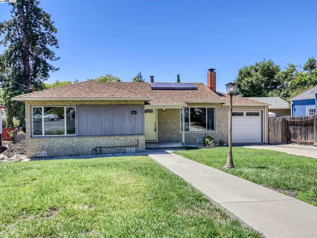 a front view of a house with a garden and yard