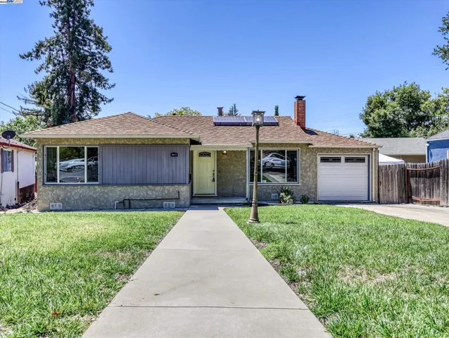 a front view of a house with a garden and plants