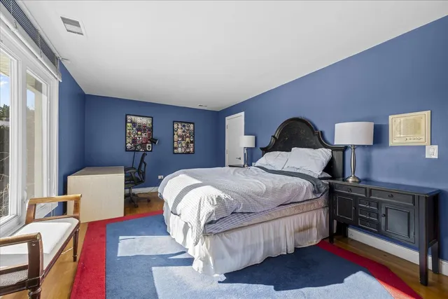 a bedroom with a bed wooden floor and window