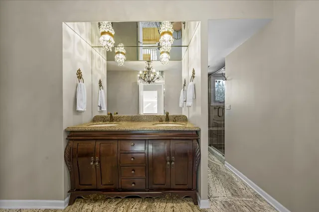 a bathroom with a granite countertop sink a mirror and a shower