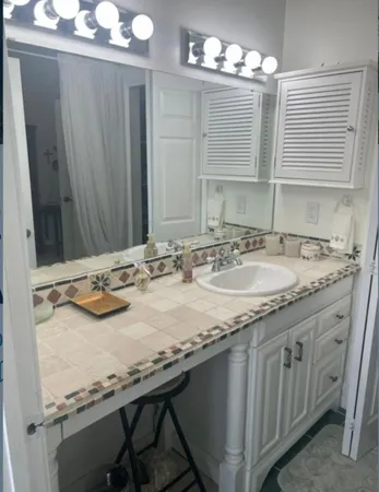 a bathroom with a granite countertop sink and a mirror