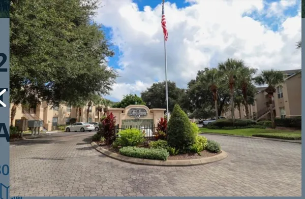 a front view of a house with garden and trees