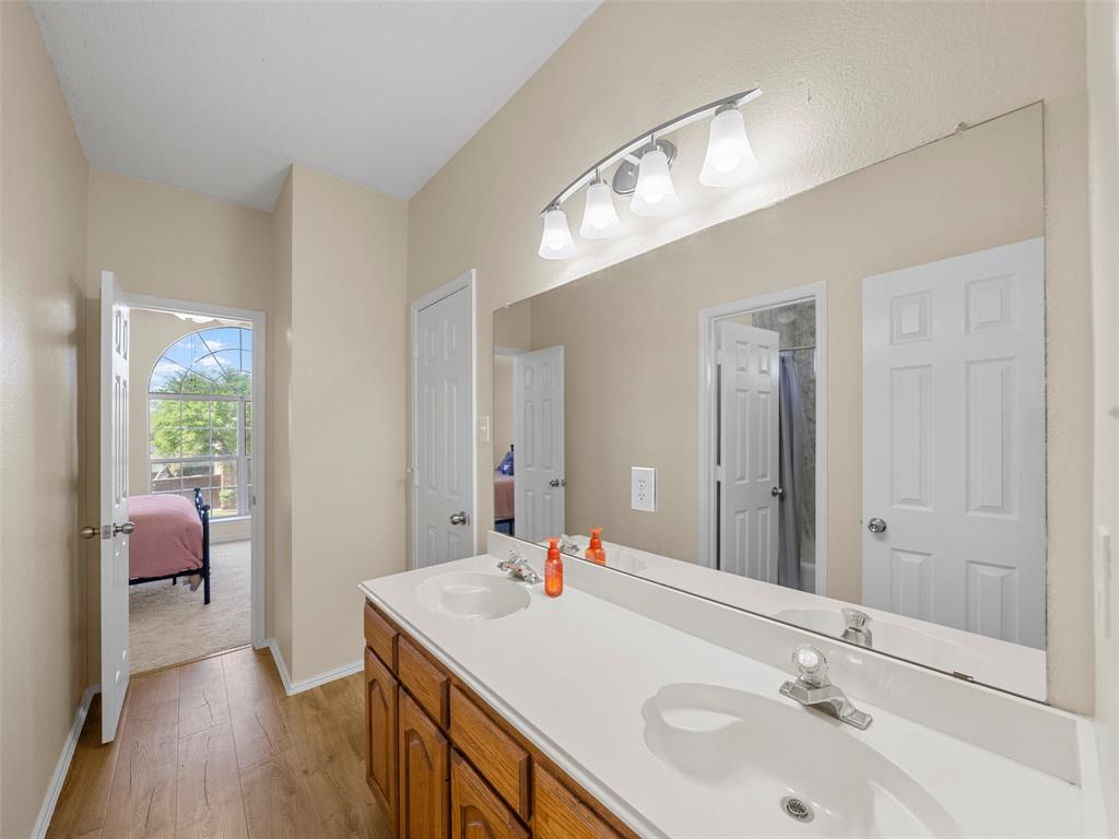 741 Aspen Court Allen, TX 75002 - Photo 30 of 40 Full bath featuring double vanity, ensuite bathroom, light wood finished floors, and a shower with shower curtain