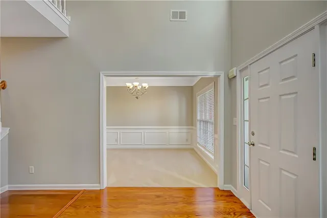 a view of an empty room with a fireplace and wooden floor