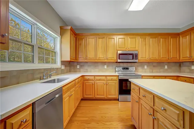 a view of empty room with window and wooden floor