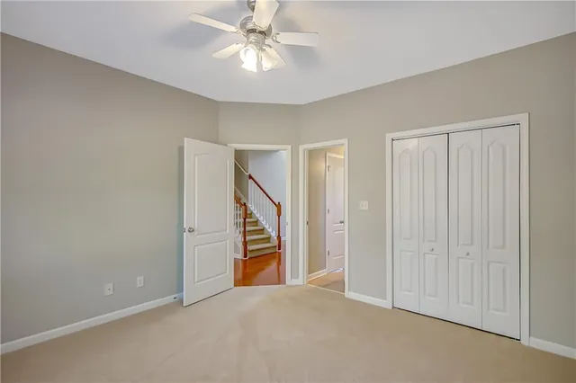 an empty room with windows and chandelier fan