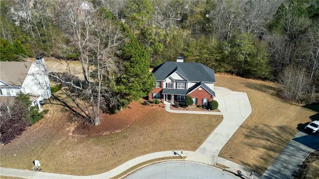 an aerial view of a house with swimming pool and red trees