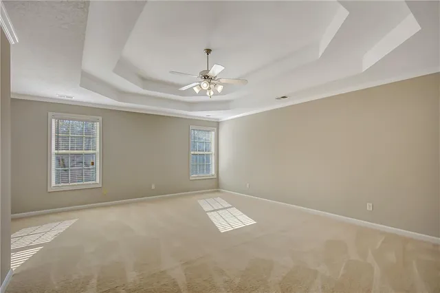 an empty room with closet and a ceiling fan