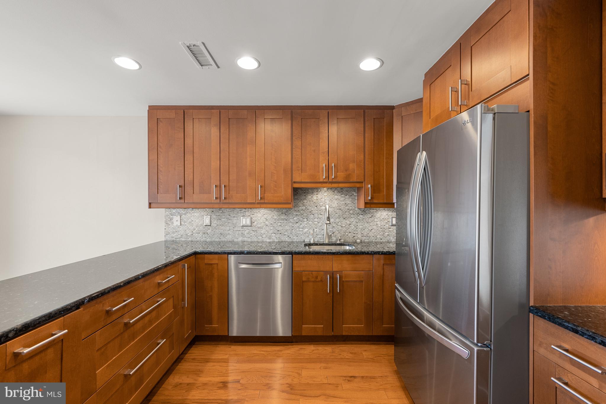 11400 Strand Drive, Unit R310 Rockville, MD 20852 - Photo 13 of 35 a kitchen with granite countertop stainless steel appliances and wooden cabinets