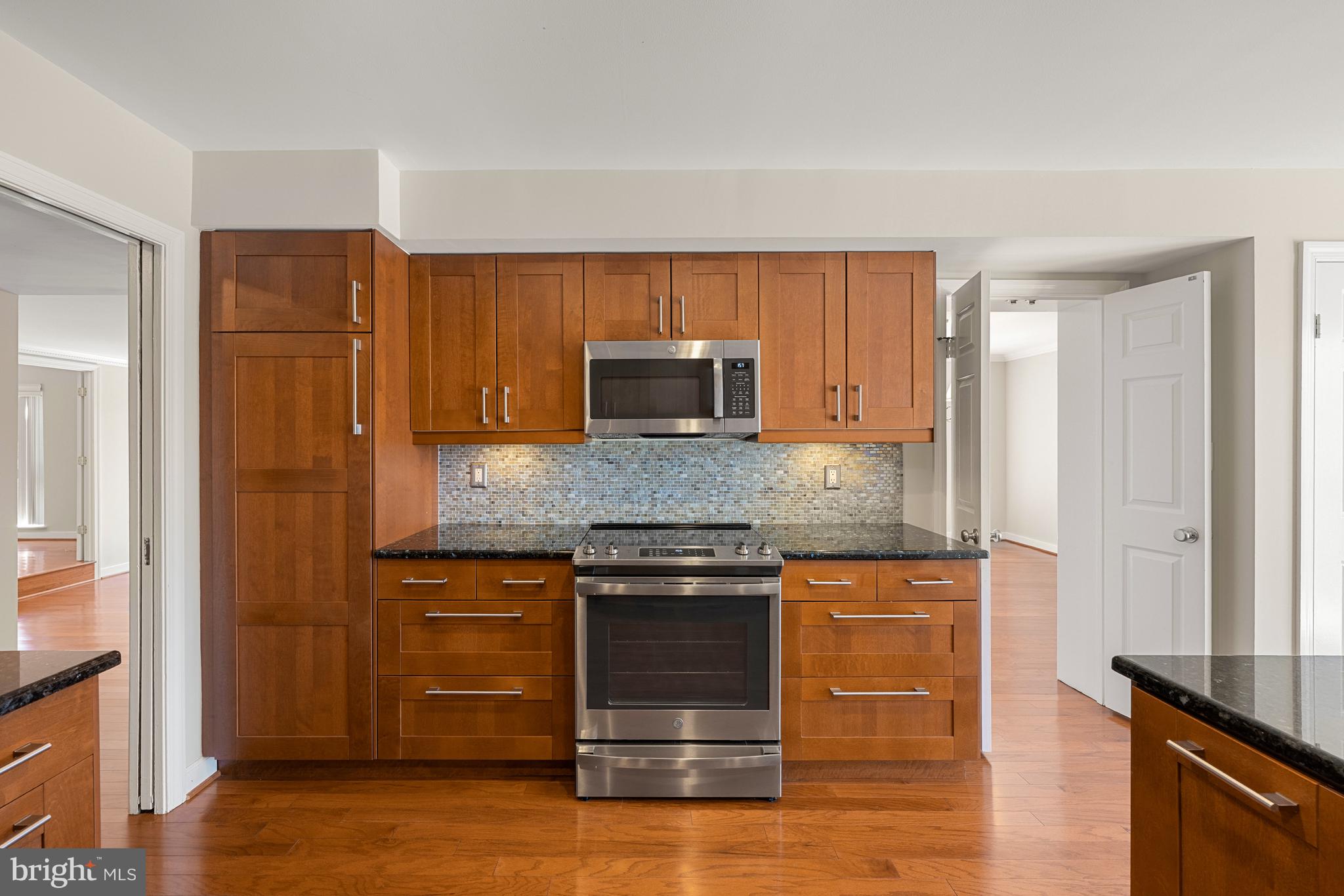 11400 Strand Drive, Unit R310 Rockville, MD 20852 - Photo 14 of 35 a kitchen with stainless steel appliances granite countertop a stove microwave and refrigerator