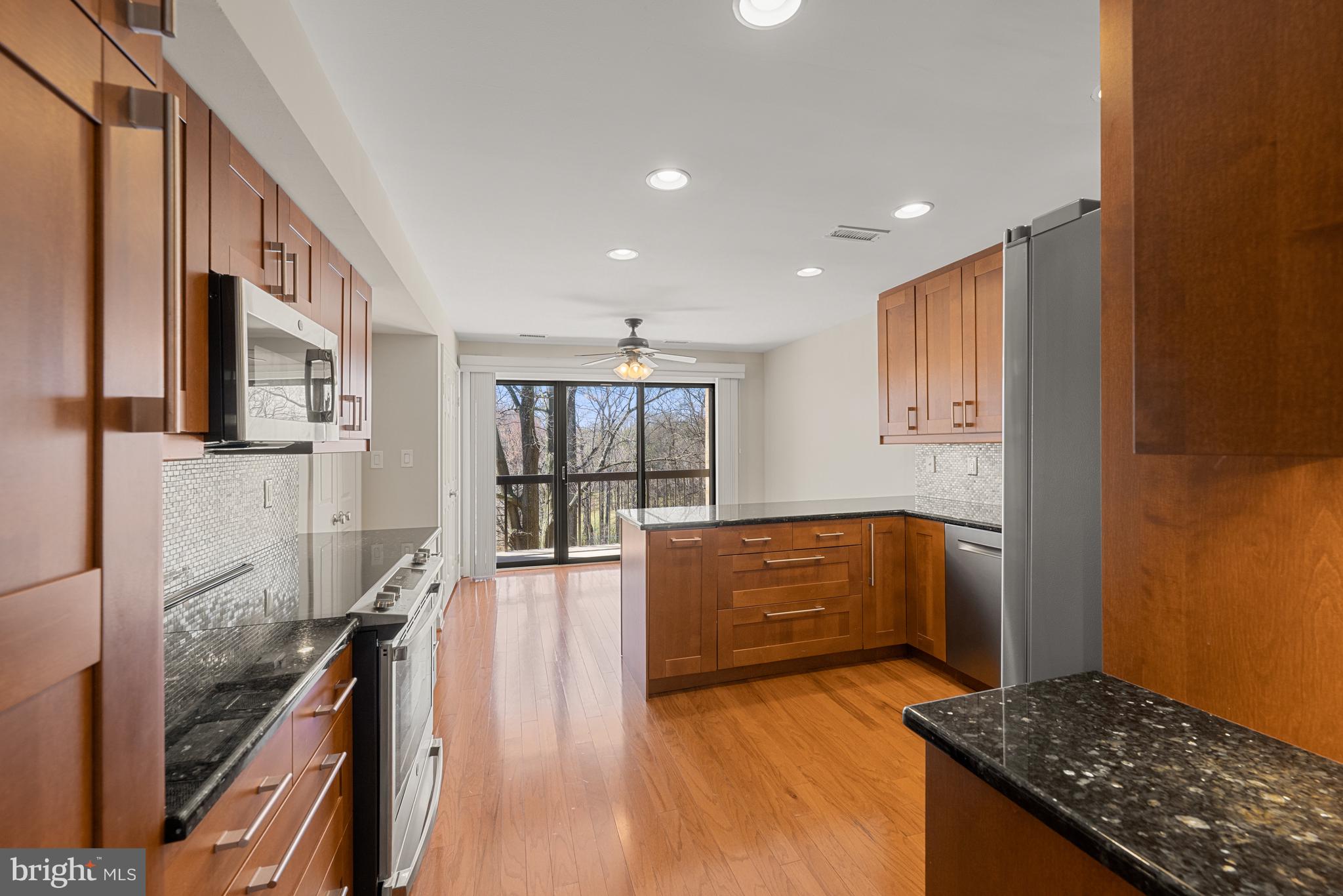 11400 Strand Drive, Unit R310 Rockville, MD 20852 - Photo 15 of 35 a kitchen with stainless steel appliances granite countertop a sink stove and refrigerator