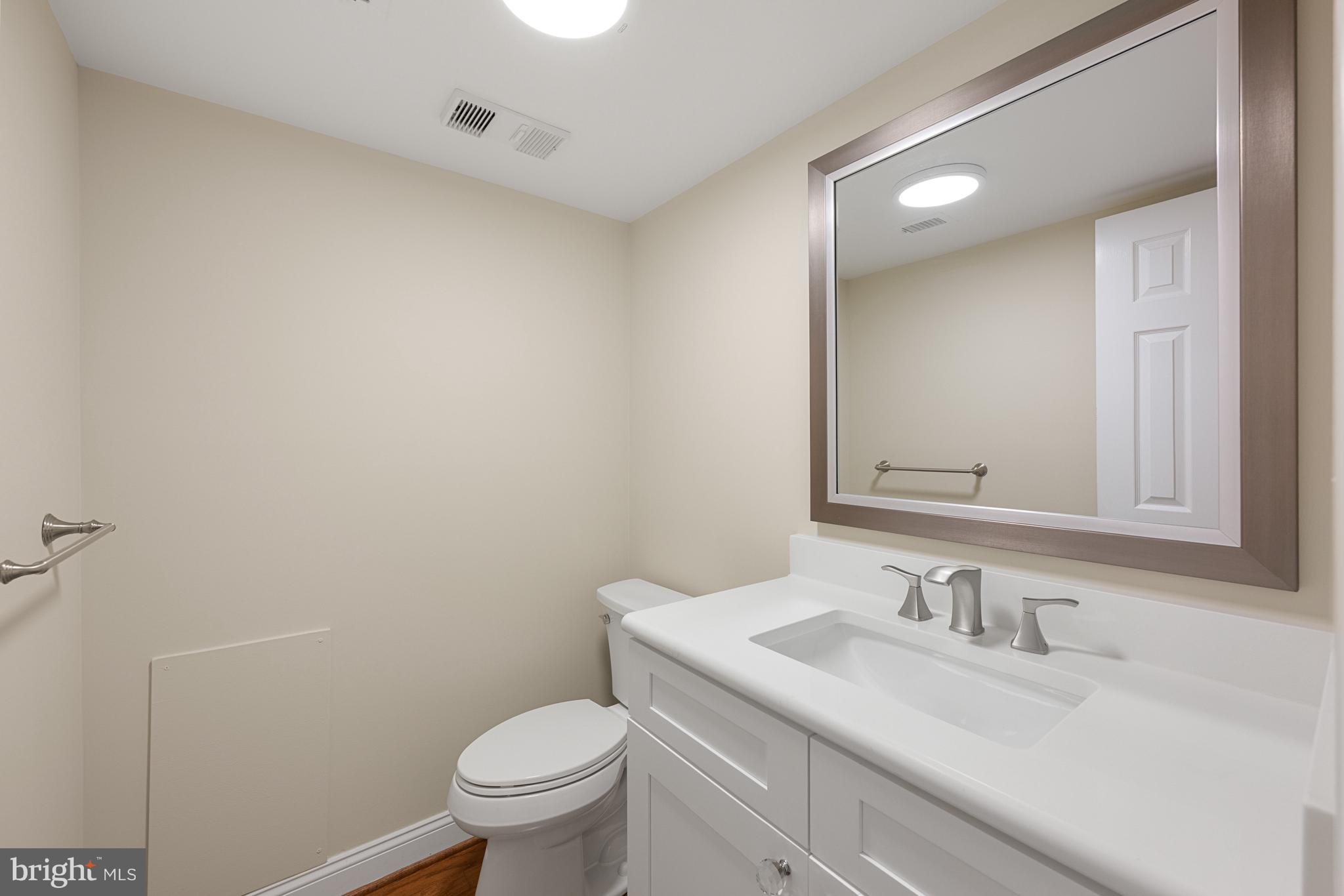 11400 Strand Drive, Unit R310 Rockville, MD 20852 - Photo 19 of 35 a bathroom with a granite countertop sink toilet and a mirror