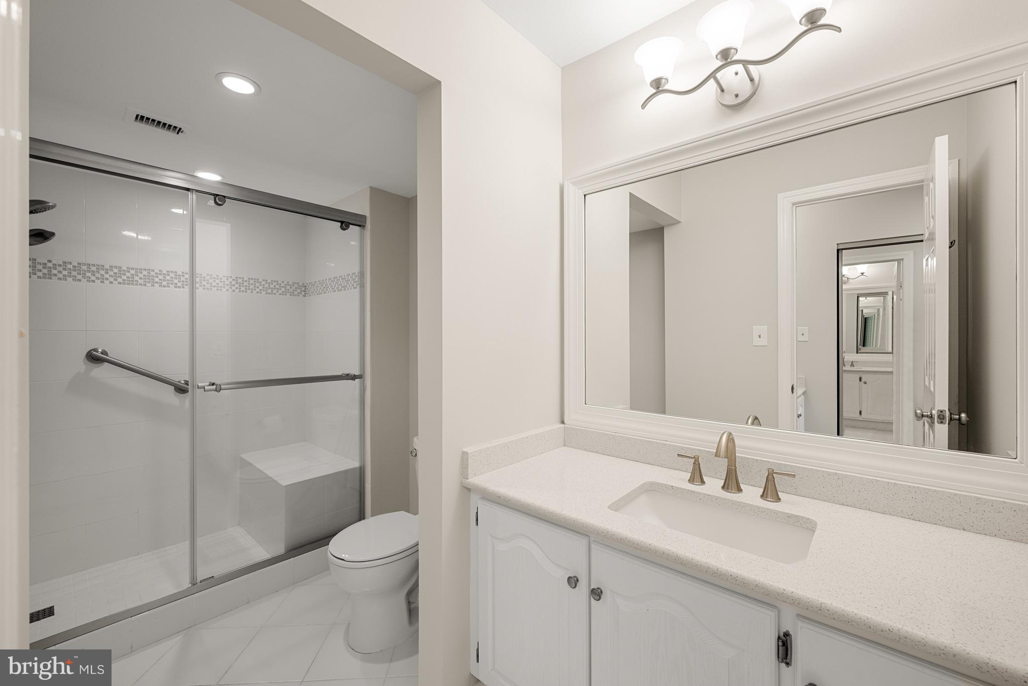 11400 Strand Drive, Unit R310 Rockville, MD 20852 - Photo 24 of 35 a bathroom with a toilet a sink a mirror and shower