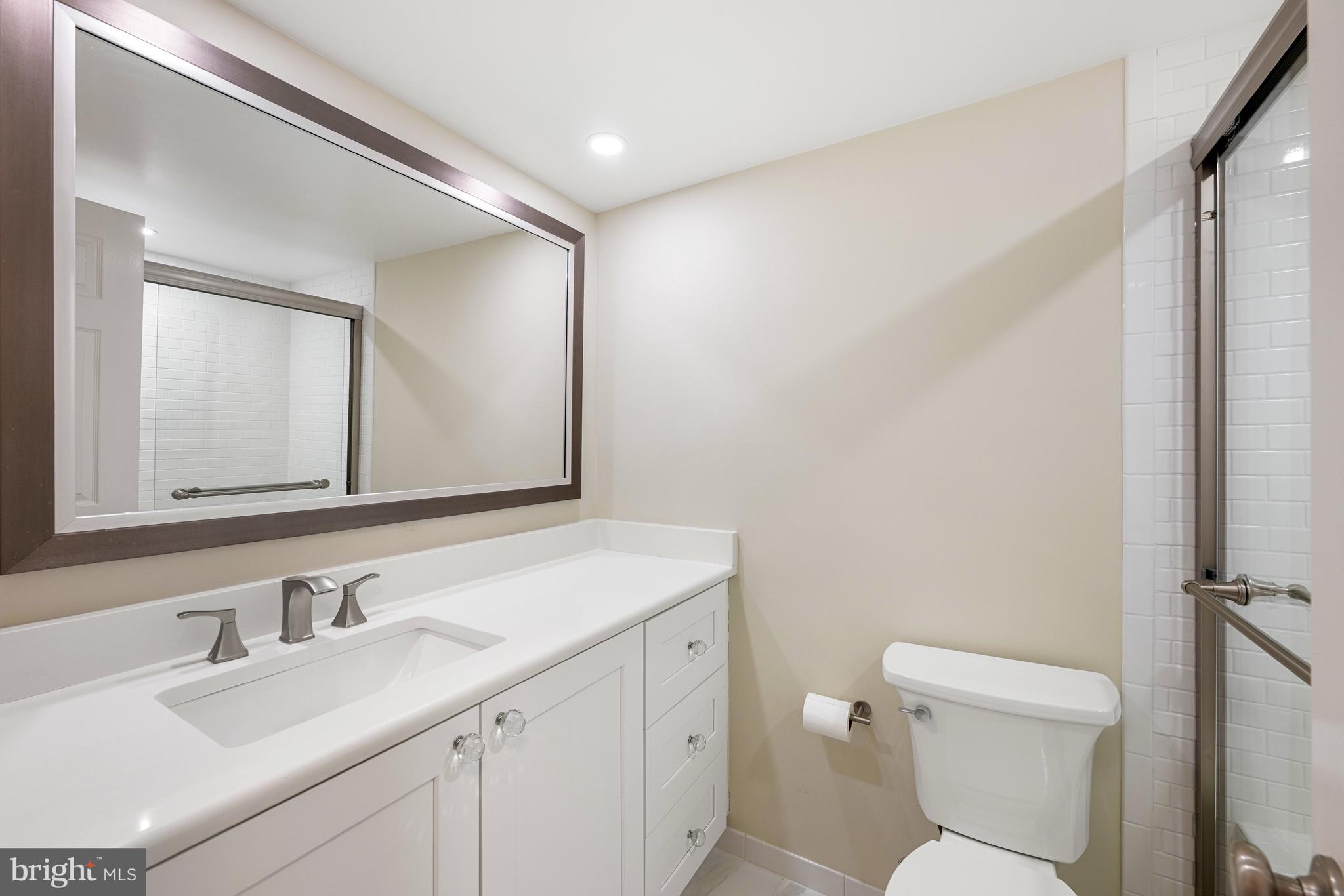 11400 Strand Drive, Unit R310 Rockville, MD 20852 - Photo 27 of 35 a bathroom with a toilet a sink a vanity and mirror