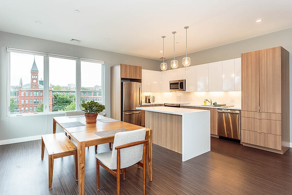 17 Ash Street Waltham, MA 02453 - Photo 12 of 32 a kitchen with a dining table chairs and refrigerator