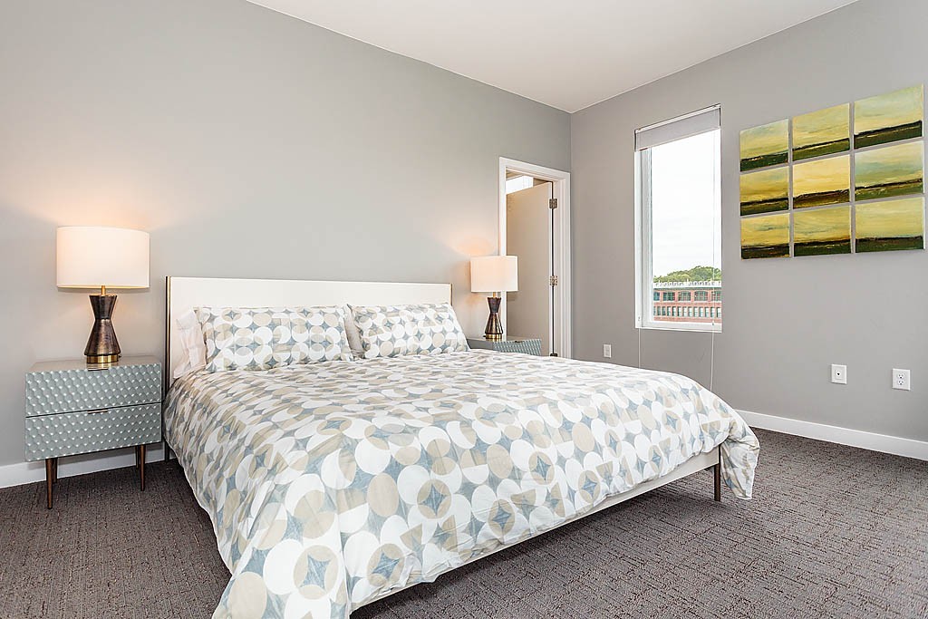 17 Ash Street Waltham, MA 02453 - Photo 17 of 32 a large bed sitting in a bedroom next to a window