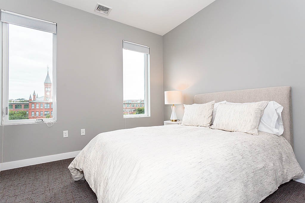 17 Ash Street Waltham, MA 02453 - Photo 18 of 32 a large bed sitting in a bedroom next to a window