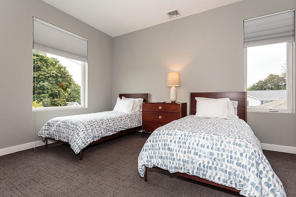 17 Ash Street Waltham, MA 02453 - Photo 19 of 32 a bedroom with two beds lamp and a large window with outer view