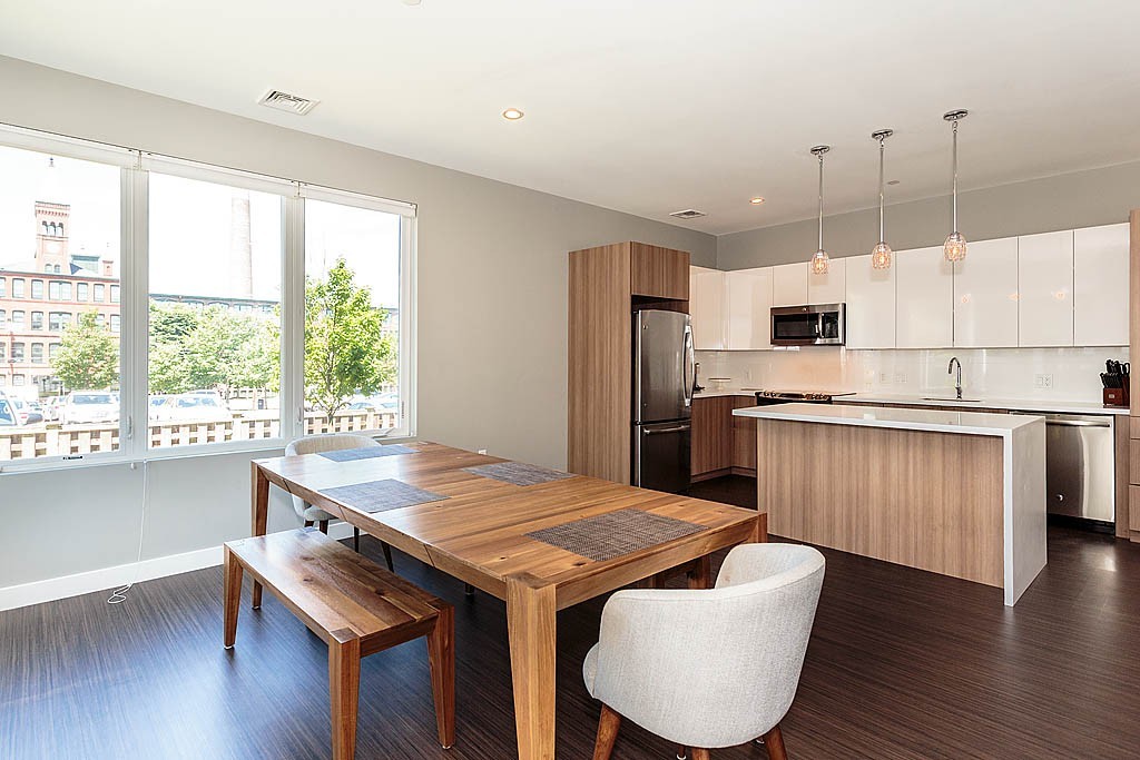 17 Ash Street Waltham, MA 02453 - Photo 4 of 32 a kitchen with kitchen island a wooden floor and white appliances